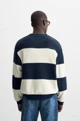 Sudadera de hombre de tejido rizo, corte holgado, con cuello redondo, manga larga y diseño a rayas horizontales en azul marino y blanco.