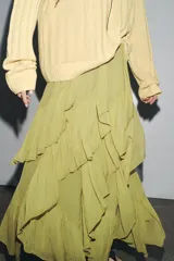 Falda midi color verde oliva, de tiro medio con cintura elástica y volantes asimétricos.