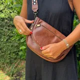 Bandolera marrón de cuero sintético con correa ancha estampada ajustable.