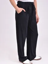 Pantalón negro de tela suave, corte recto y cintura alta con cordón ajustable.