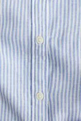 Blusa celeste y blanca a rayas verticales, de corte recto, con cuello redondo, cierre frontal con botones y mangas 3/4 abullonadas con puños elásticos.