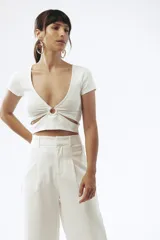 Crop top celeste de tejido de punto acanalado, con escote en V y detalle de abertura circular en el centro.