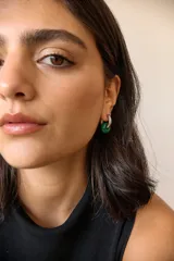 Aros de acero quirúrgico hipoalergénico con forma de argolla plateada y dije circular colgante de piedra natural color azul.