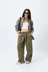 Pantalón cargo baggy con estampado de camuflaje en tonos verde y marrón, cintura elástica y bolsillos laterales.