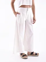 Pantalón ancho de tiro alto, color negro, con pliegues frontales y botones decorativos en la cintura.