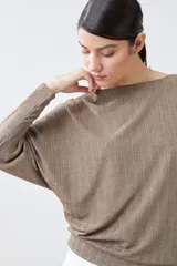 Blusa roja de tejido de punto acanalado, con escote barco y mangas dolman largas.