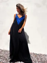 Vestido largo negro de terciopelo con escote en V y apliques de lentejuelas azules en el corpiño.