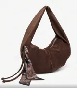 Bolso hobo de cuero sintético color bordó, con tachas plateadas.