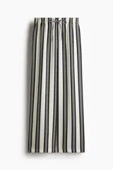 Pantalón amplio de tiro alto con cintura elástica y cordón de ajuste. Diseño a rayas verticales en blanco y negro.