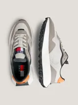 Zapatillas Tommy Jeans de estilo running, color gris con detalles en naranja y negro. Confeccionadas en piel y materiales reciclados.