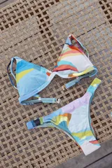 Conjunto de bikini turquesa con corpiño triangular de corte fijo, breteles regulables y almohadillas desmontables, y bombacha vedetina con frunce elástico en los costados.
