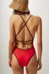 Malla enteriza roja con breteles finos marrones y ribete marrón en escote y cavado de pierna.