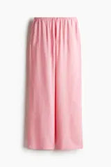 Pantalón de tiro bajo color rosa, confeccionado en tejido liviano con lino en la trama. Presenta elástico revestido y cordón para ajustar en la cintura, bolsillos al bies y piernas rectas.