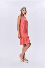 Vestido corto color salmón, de breteles finos y corte recto con volado en el ruedo.
