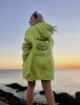 Hoodie oversize color verde neón con capucha, bolsillo canguro y puños ajustados. Estampado pequeño en el pecho con logo de la marca.