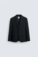 Blazer negro regular fit confeccionado en tejido de lana. Cuello con solapas de muesca y manga larga acabada en puño con detalle de botones. Bolsillos de vivo en pecho y de solapa en cadera. Detalle de bolsillo interior. Bajo con aberturas en espalda. Cierre frontal de botonadura.