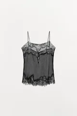 Top negro semitransparente de tejido plisado con escote pico y tirantes finos. Detalle de encaje combinado a tono y cierre en la espalda con botones forrados.