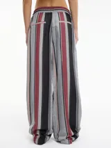 Pantalón de viscosa y poliéster con rayas verticales en tonos gris, negro y bordó. Tiene tiro medio-alto, pretina elástica con cordón ajustable y bolsillos laterales.