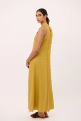 Vestido largo color fucsia de lino italiano, con cuello redondo a la base y sin mangas. Tiene detalle desflecado en el cuello y a lo largo del vestido.