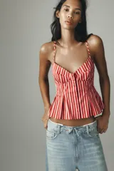 Top con estampado a rayas verticales rojas y blancas, escote pico, tirantes finos ajustables, detalle de pliegues y cierre frontal con botones.