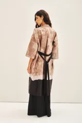 Kimono largo hasta la rodilla con estampado abstracto en tonos marrones y negros. Tiene mangas amplias 3/4 y lazo en la cintura.