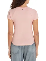 Remera rosa de algodón con cuello redondo y mangas cortas raglán. Estampado frontal con el logo de Tommy Hilfiger en negro.