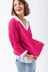Sweater fucsia de punto con escote en V y mangas largas con diseño trenzado. Corte holgado.