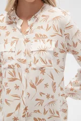 Camisa de viscosa con estampado floral en tonos azul, beige y blanco. Tiene cuello mao, mangas largas y bolsillos en el pecho.