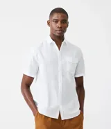Camisa de hombre de manga corta en lino, color blanco, con bolsillo y botonadura frontal.