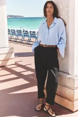 Pantalón blanco de lino, de tiro alto con pinzas delanteras, bolsillos frontales y falsos bolsillos con solapa en la espalda. Incluye cinturón marrón.