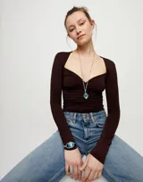 Collar largo de la marca UNOde50, confeccionado en aleación de metales con baño de plata de ley. Presenta una cadena de eslabones rectangulares y un colgante central con un cristal facetado de color azul en forma ovalada.