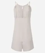 Conjunto de pijama short doll color crema, compuesto por un top de breteles finos con escote en V y detalles de encaje, y un short con cintura elástica y detalles de encaje en los laterales.