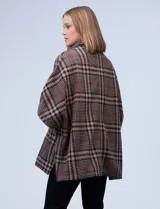 Poncho de tejido soft, marca Weatherproof, con estampado Príncipe de Gales en tonos marrón, beige, azul marino y rojo. Presenta cuello alto con cierre metálico dorado y bolsillos delanteros.