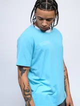 Remera color arena de corte clásico con cuello redondo ribeteado en blanco y logo Umbro estampado en el pecho.