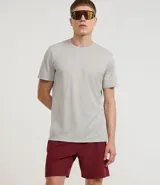 Bermuda deportiva color beige, de tejido plano de poliéster, con cintura elástica y cordón de ajuste. Posee bolsillos laterales con cierre y recortes laterales con perforaciones.