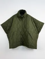 Poncho acolchado color mostaza con cuello alto y abertura frontal con cierre. Presenta un patrón capitoné de formas ovaladas y bolsillos delanteros.