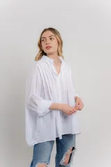 Camisa oversize blanca de algodón con pliegues frontales.