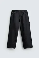Pantalón de jean negro de corte amplio, con bolsillos delanteros y traseros, presilla portaherramientas en la pierna derecha y costuras a contratono.