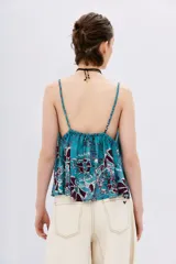 Top celeste con estampado de flores color borgoña, escote en V y breteles trenzados.