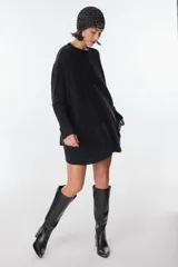 Sweater tejido artesanalmente en Uruguay, color beige con rayas verticales color camel y diseño de trenzas. Tiene bolsillos frontales y puños ajustados.