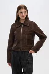 Chaqueta marrón de gamuza con cuello camisero, cierre frontal con cremallera, bolsillos de parche y costuras en contraste.