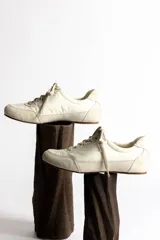 Zapatillas deportivas color crema con detalles en gamuza beige.