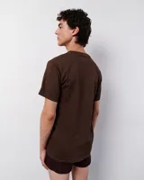 Remera marrón de algodón con estampa de una casa, un hombre, un caballo y un paisaje.