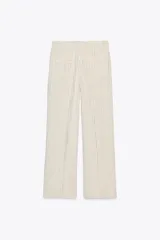 Pantalón de tiro alto color crudo con finas rayas verticales negras, pinzas delanteras, bolsillos frontales y falsos bolsillos de vivo en la espalda.