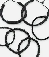 Set de seis pulseras negras para hombre, que incluyen tres pulseras trenzadas con ajuste corredizo y tres pulseras de cuentas con elástico.
