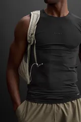 Musculosa deportiva negra de tejido elástico compresivo con cuello redondo y sisa ancha.
