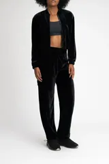Pantalón jogger negro de terciopelo con cintura media ajustable con cordón, bolsillos laterales tipo cargo y puños elásticos.
