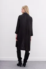 Kimono largo hasta la rodilla, color negro con estampado jacquard. Tiene solapa, botón frontal, tajos laterales y bolsillos ojal con solapa en el frente.