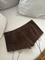 Short marrón de gamuza con cintura alta, corte ajustado y cordones cruzados en los laterales.