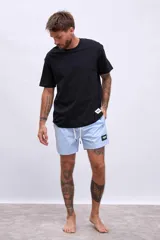 Short de baño celeste con cordón blanco en la cintura y logo negro en la pierna izquierda.
